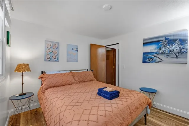 a bedroom with a bed and painting on the wall