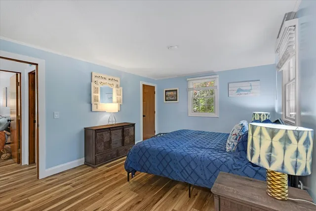 a spacious bedroom with a bed and wooden floor