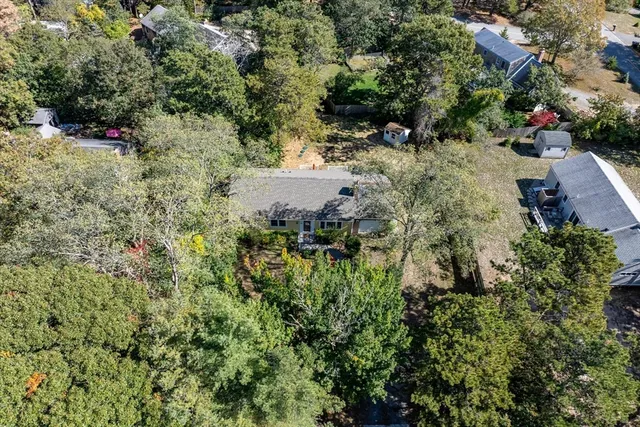 an aerial view of residential house with outdoor space and trees all around