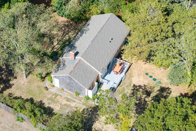 an aerial view of a house with a yard and large tree