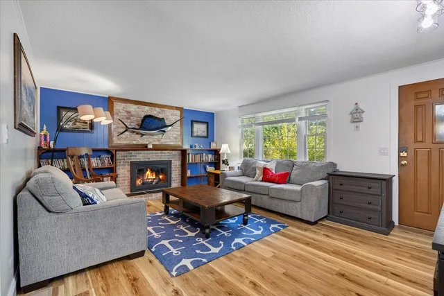 a living room with furniture a fireplace and a window
