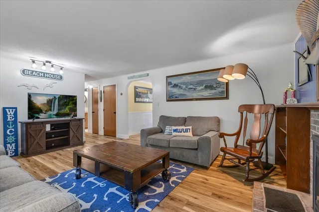 a living room with furniture a flat screen tv and a table