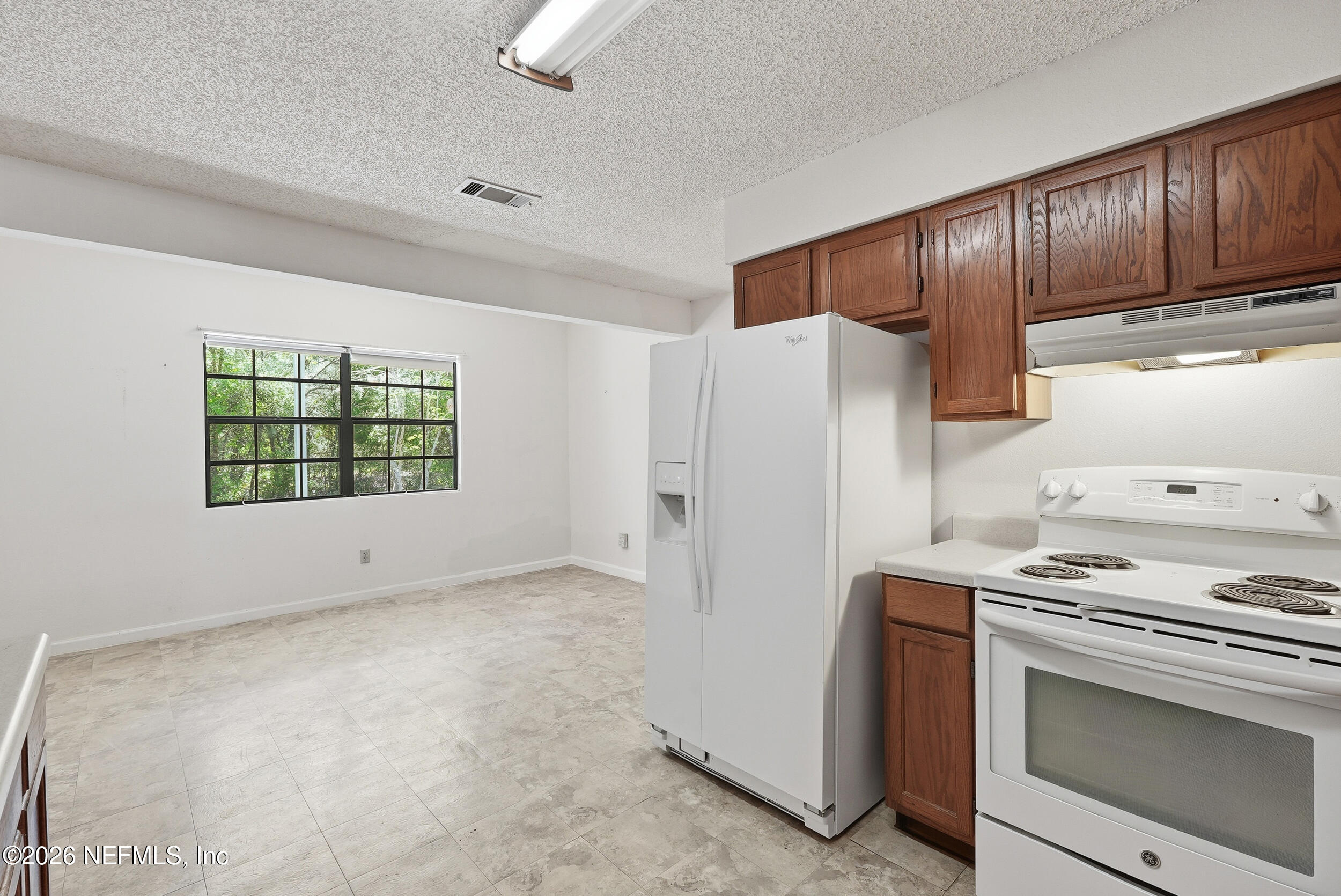 7593 Silver Sands Road Keystone Heights, FL 32656 - Photo 12 of 36 a kitchen with a refrigerator stove and cabinets