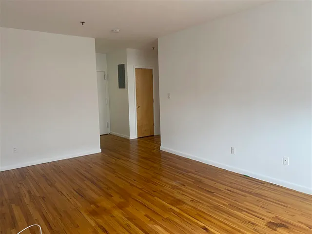 a view of an empty room with wooden floor