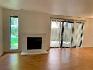 a view of an empty room with glass door and a window