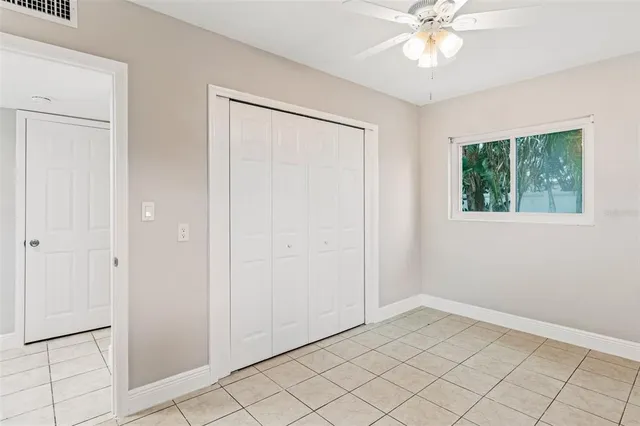 a view of an empty room and chandelier fan