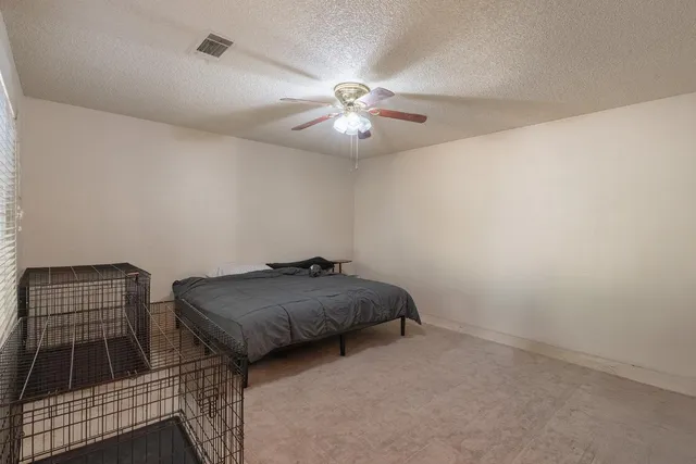 a room with a bed and a ceiling fan