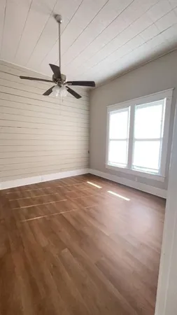 an empty room with a window and a ceiling fan
