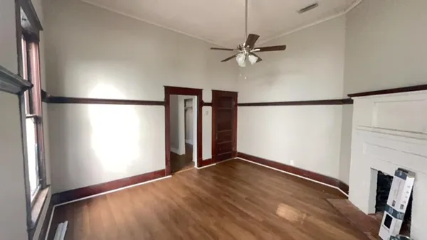 a view of a room with wooden floor closet and a ceiling fan