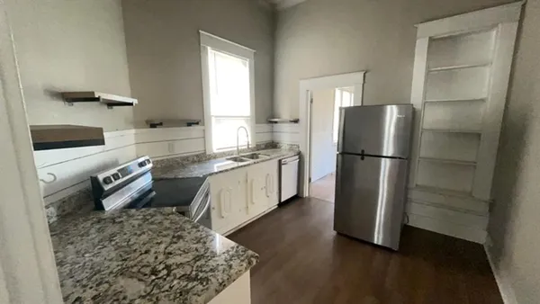 a kitchen with a refrigerator and a stove