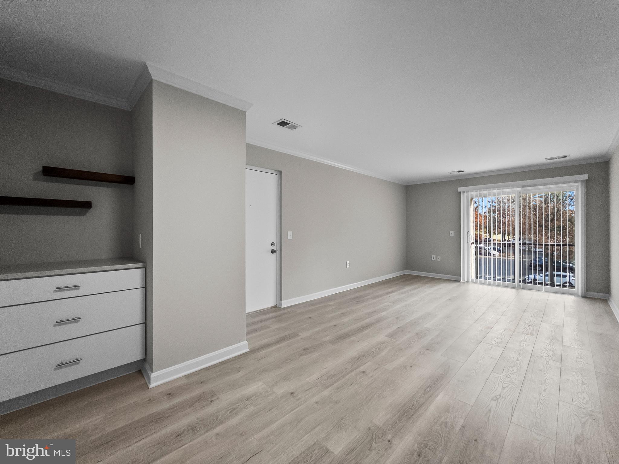 18304 Streamside Drive, Unit 301 Gaithersburg, MD 20879 - Photo 13 of 31 a view of an empty room with wooden floor and a window