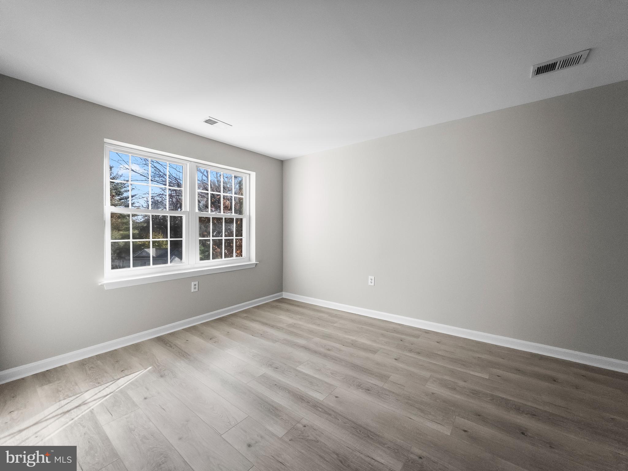 18304 Streamside Drive, Unit 301 Gaithersburg, MD 20879 - Photo 14 of 31 a view of an empty room with wooden floor and windows
