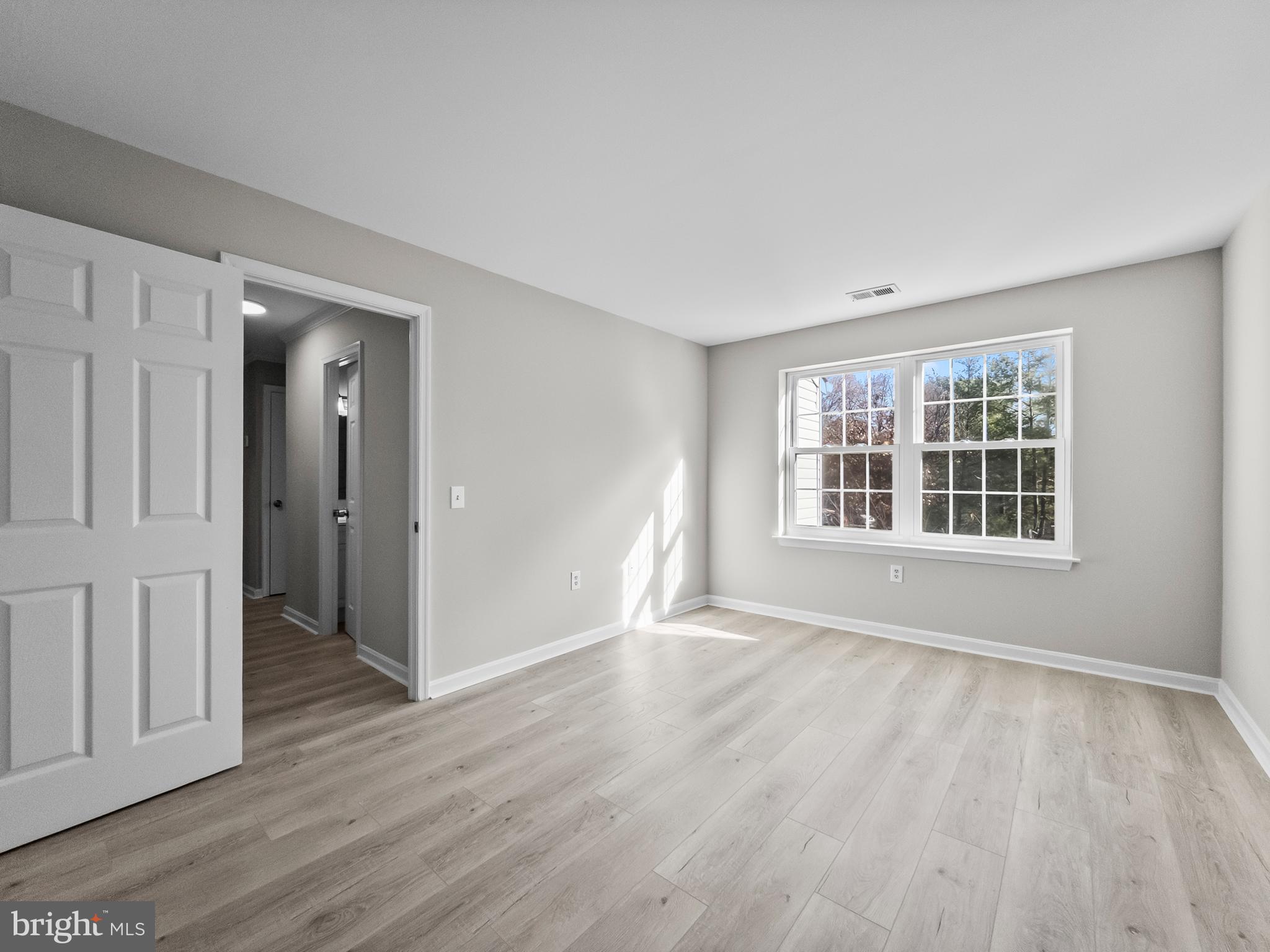 18304 Streamside Drive, Unit 301 Gaithersburg, MD 20879 - Photo 16 of 31 a view of an empty room with wooden floor and a window