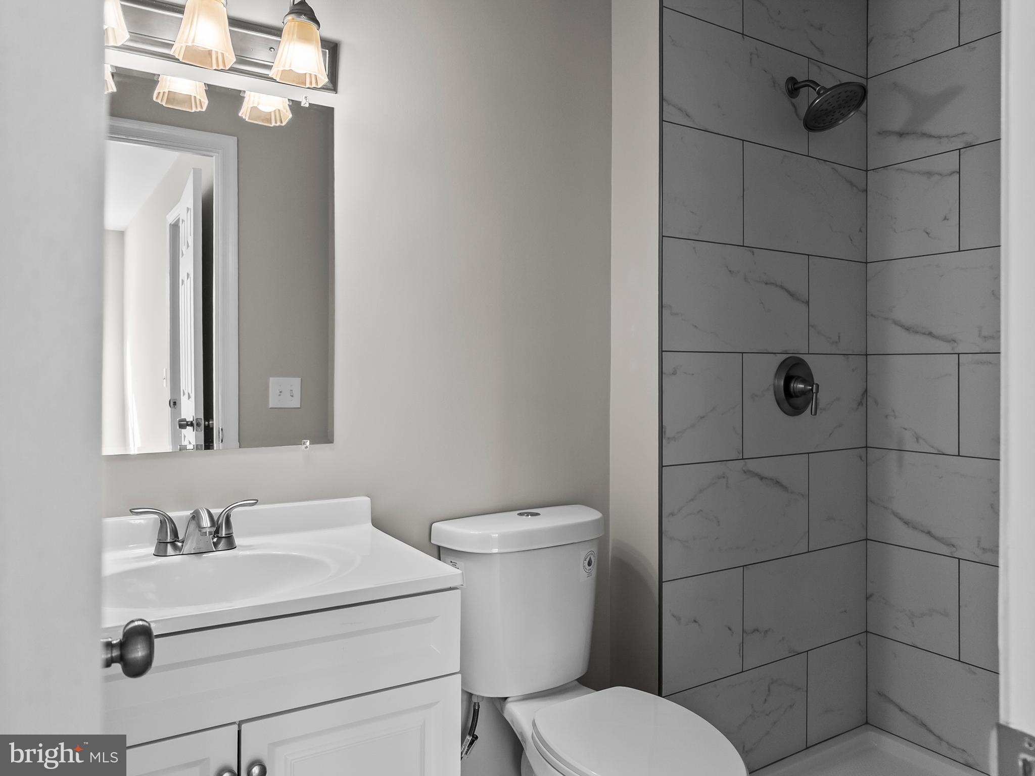 18304 Streamside Drive, Unit 301 Gaithersburg, MD 20879 - Photo 17 of 31 a bathroom with a toilet sink vanity and mirror
