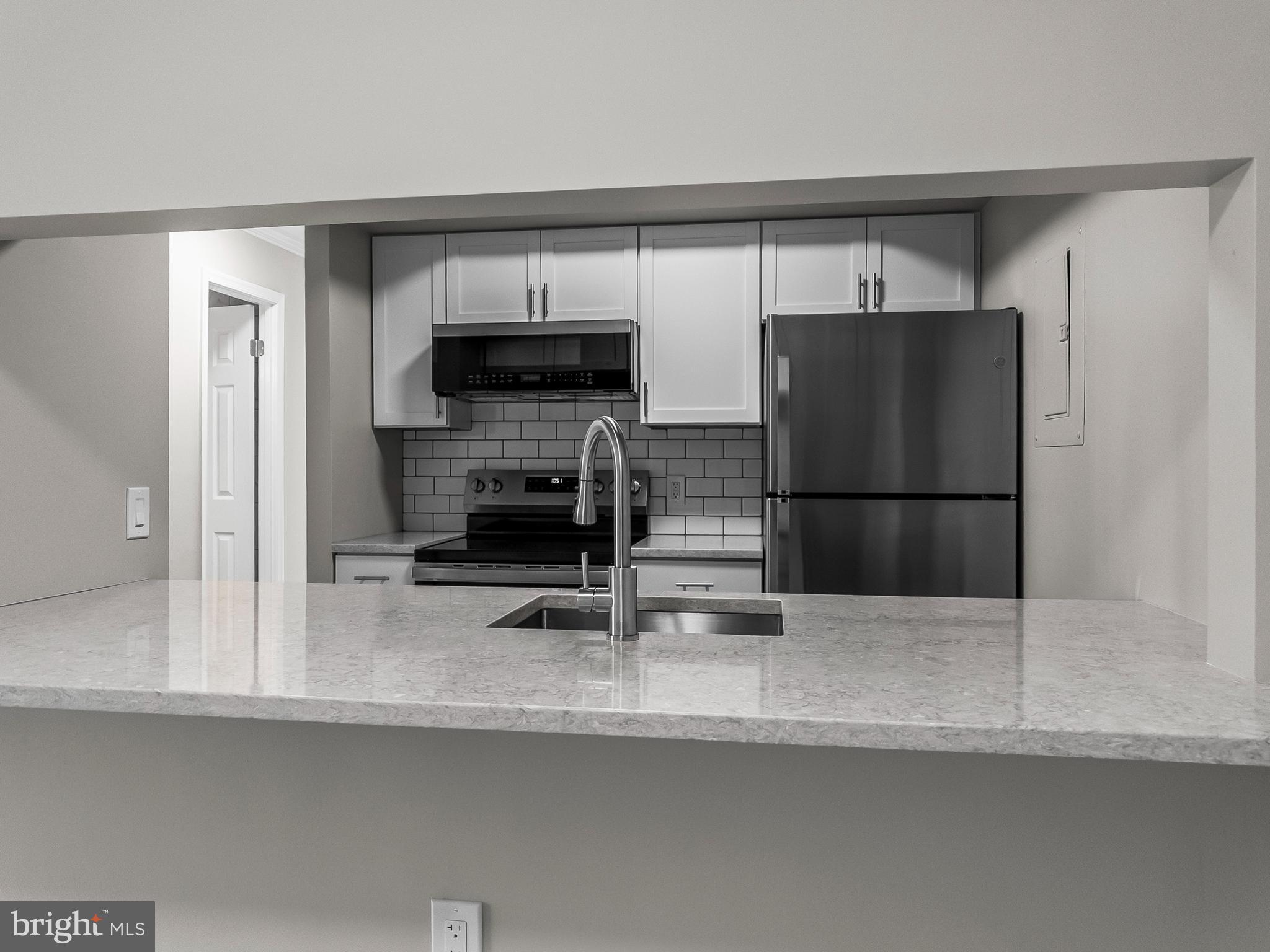 18304 Streamside Drive, Unit 301 Gaithersburg, MD 20879 - Photo 2 of 31 a kitchen with stainless steel appliances a refrigerator and a sink