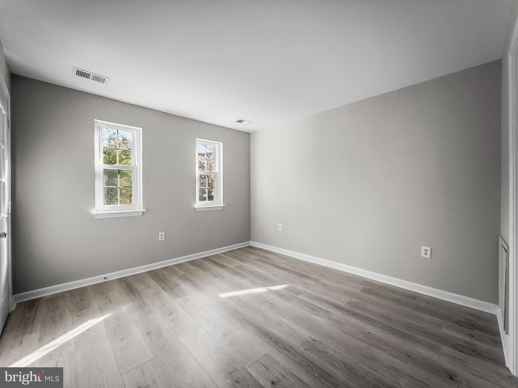 18304 Streamside Drive, Unit 301 Gaithersburg, MD 20879 - Photo 21 of 31 an empty room with wooden floor and windows