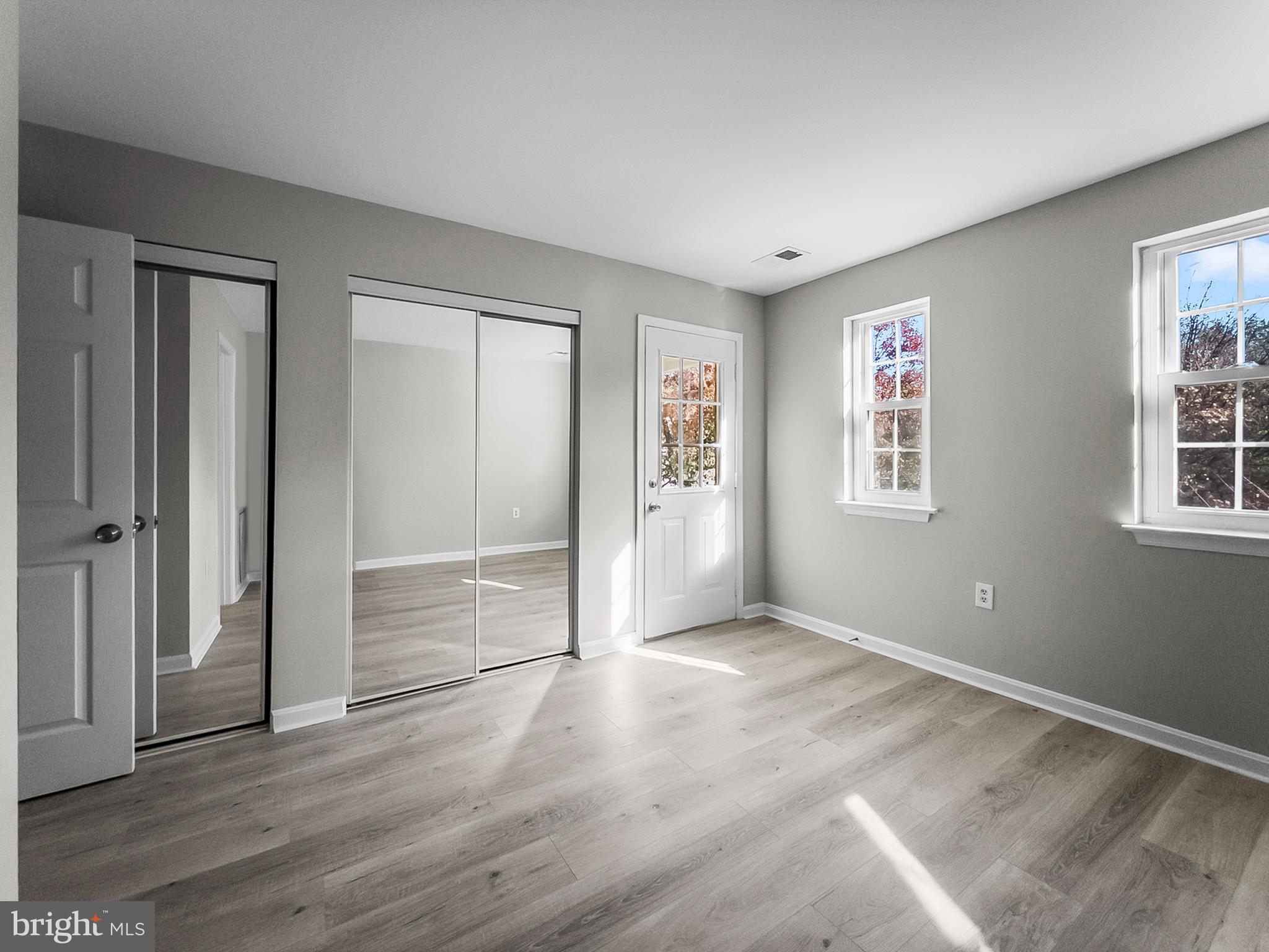 18304 Streamside Drive, Unit 301 Gaithersburg, MD 20879 - Photo 22 of 31 an empty room with wooden floor and windows