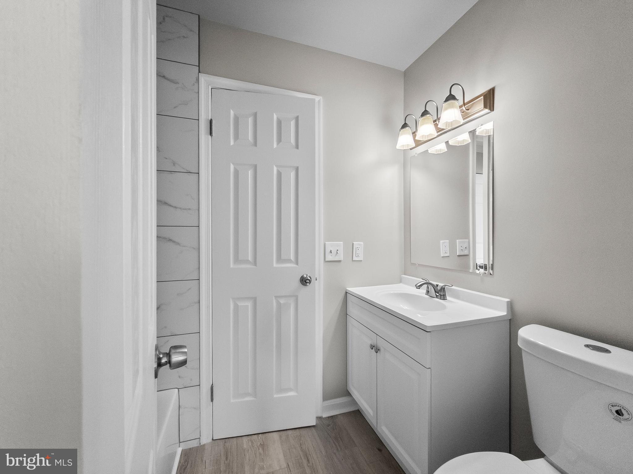 18304 Streamside Drive, Unit 301 Gaithersburg, MD 20879 - Photo 23 of 31 a bathroom with a toilet a sink and mirror