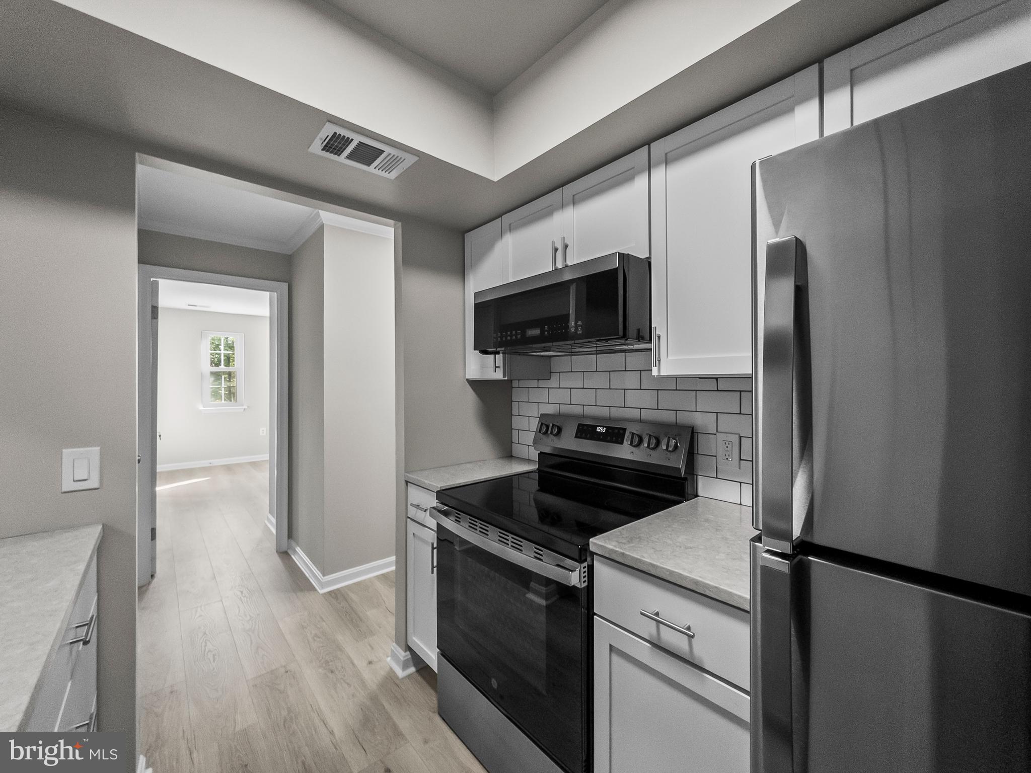 18304 Streamside Drive, Unit 301 Gaithersburg, MD 20879 - Photo 5 of 31 a kitchen with a refrigerator stove and microwave