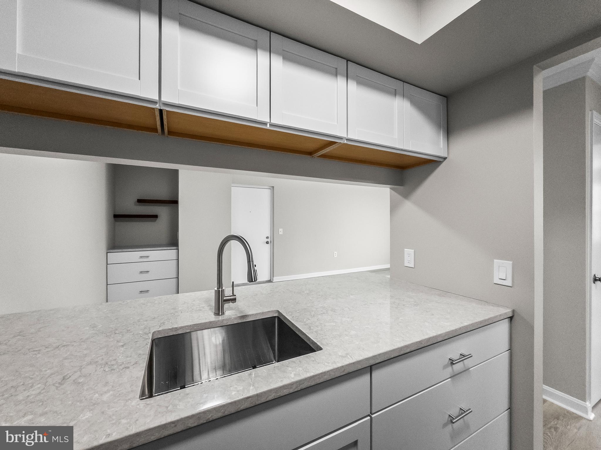 18304 Streamside Drive, Unit 301 Gaithersburg, MD 20879 - Photo 6 of 31 a kitchen with a sink and cabinets