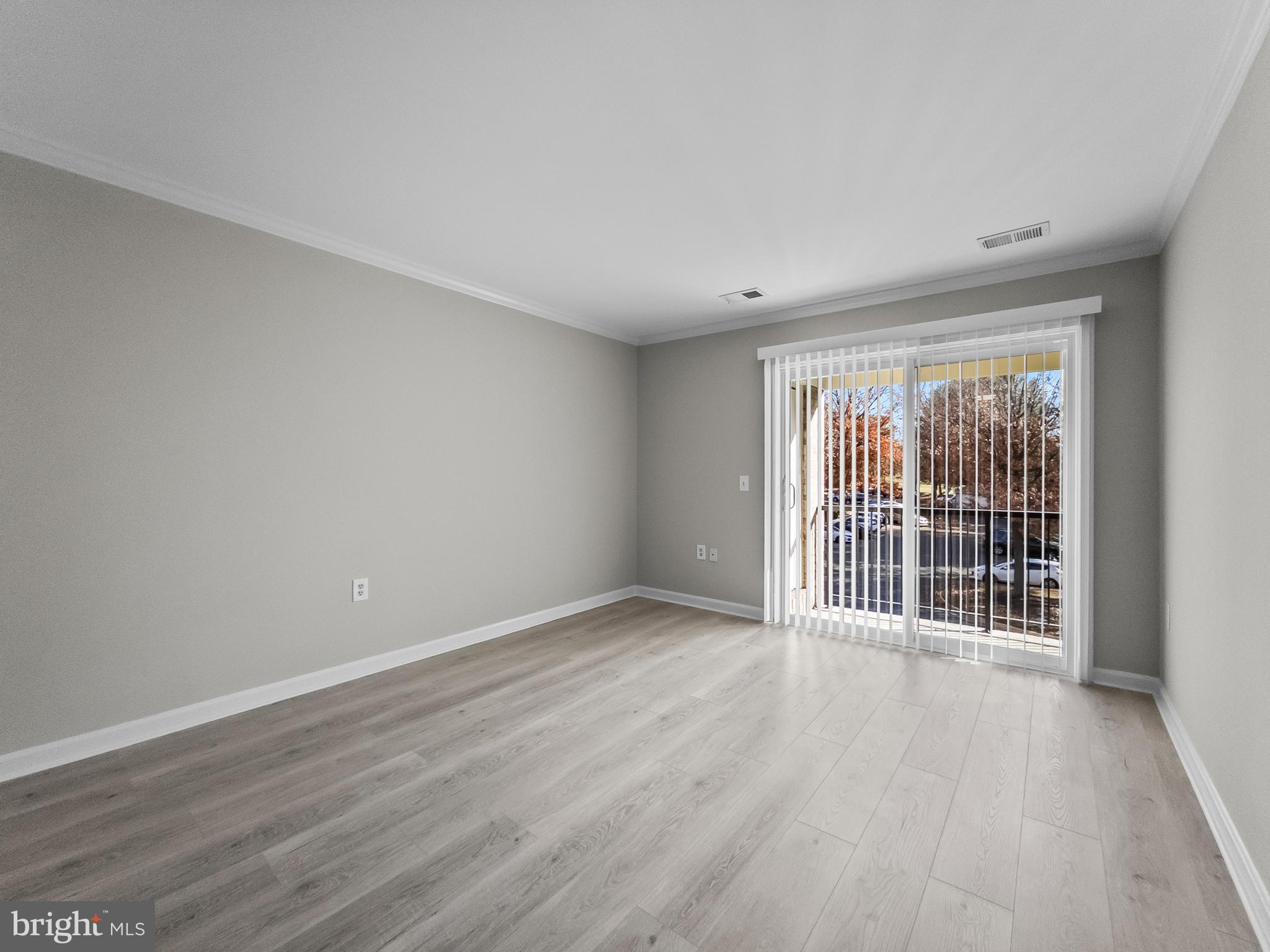 18304 Streamside Drive, Unit 301 Gaithersburg, MD 20879 - Photo 9 of 31 a view of an empty room with wooden floor and a window