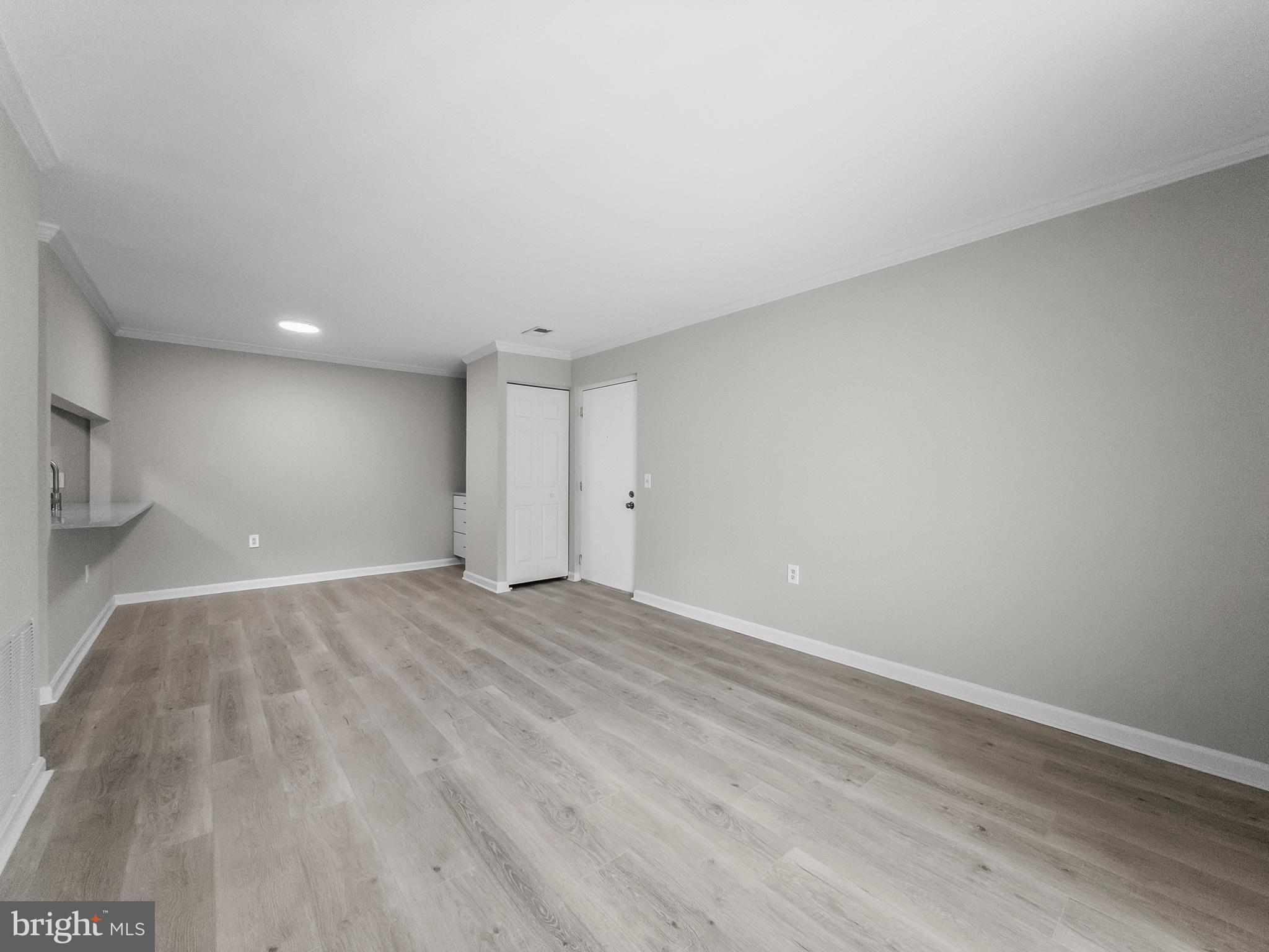 18304 Streamside Drive, Unit 301 Gaithersburg, MD 20879 - Photo 10 of 31 a view of an empty room with wooden floor