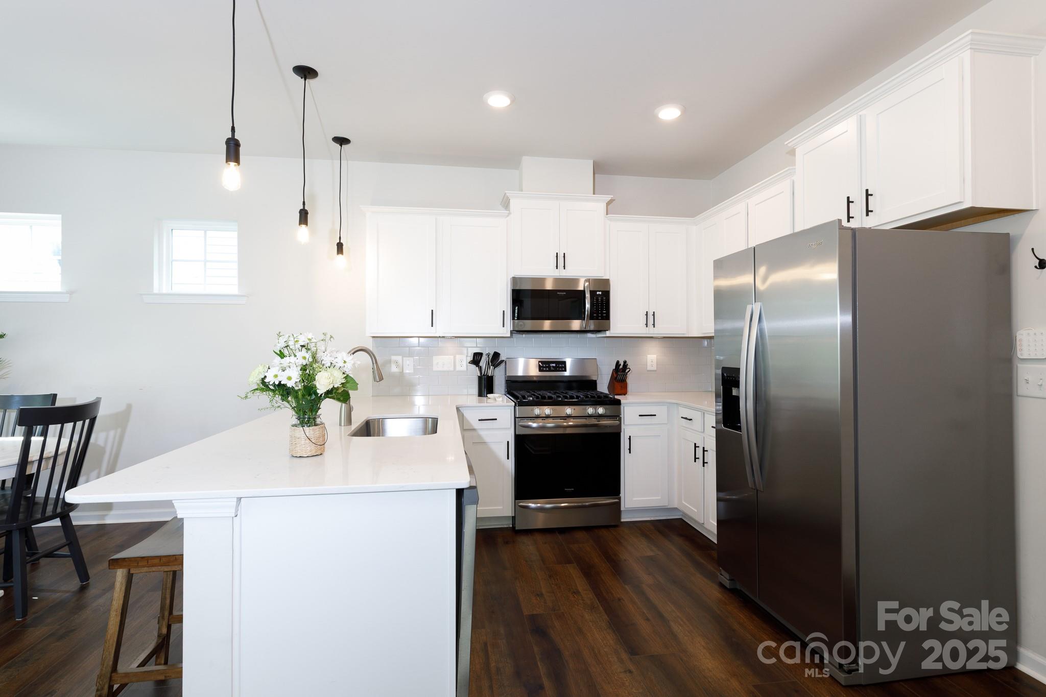 1207 Loggerhead Drive Lancaster, SC 29720 - Photo 7 of 25 a kitchen with a refrigerator a stove a microwave and wooden floor