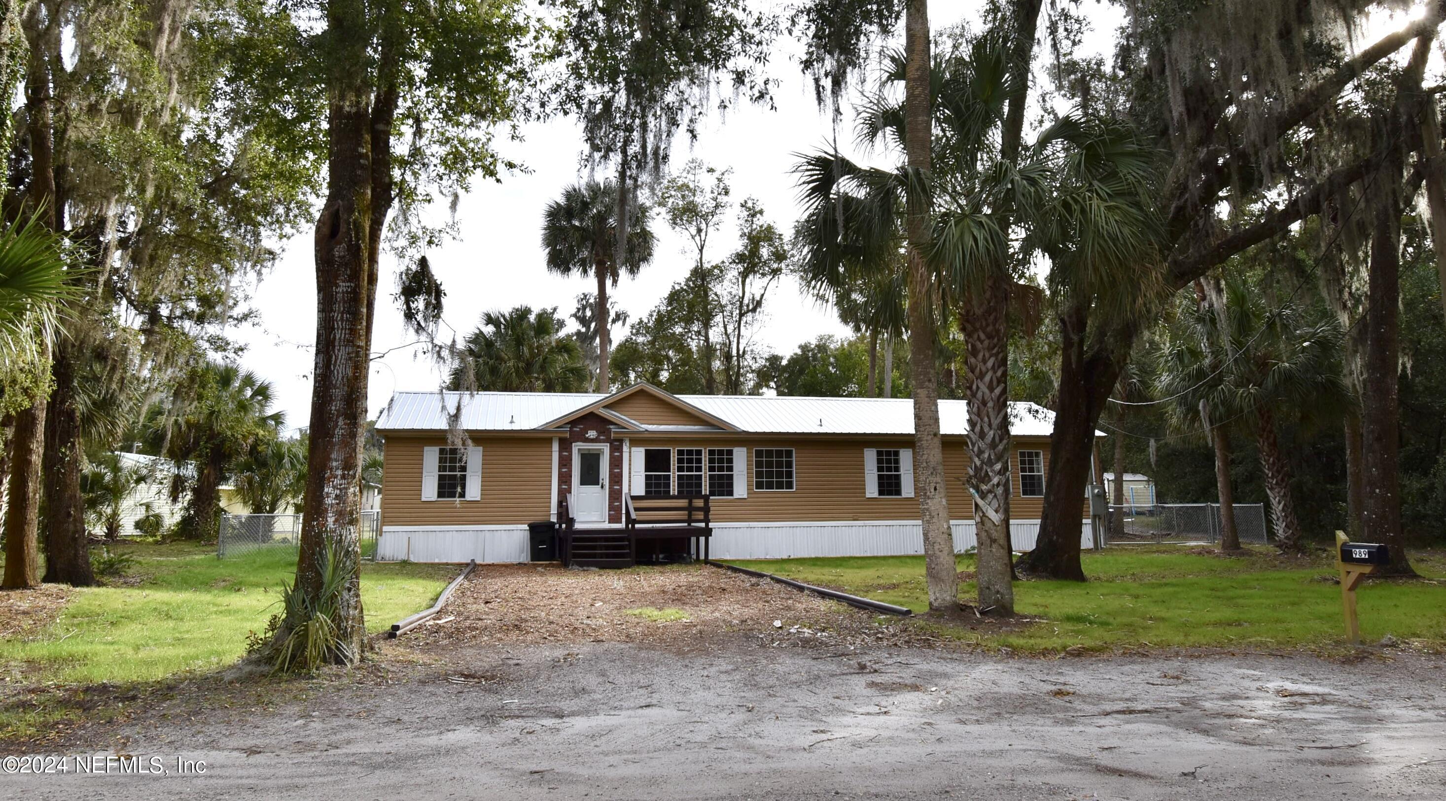a view of a house with a yard and tree s