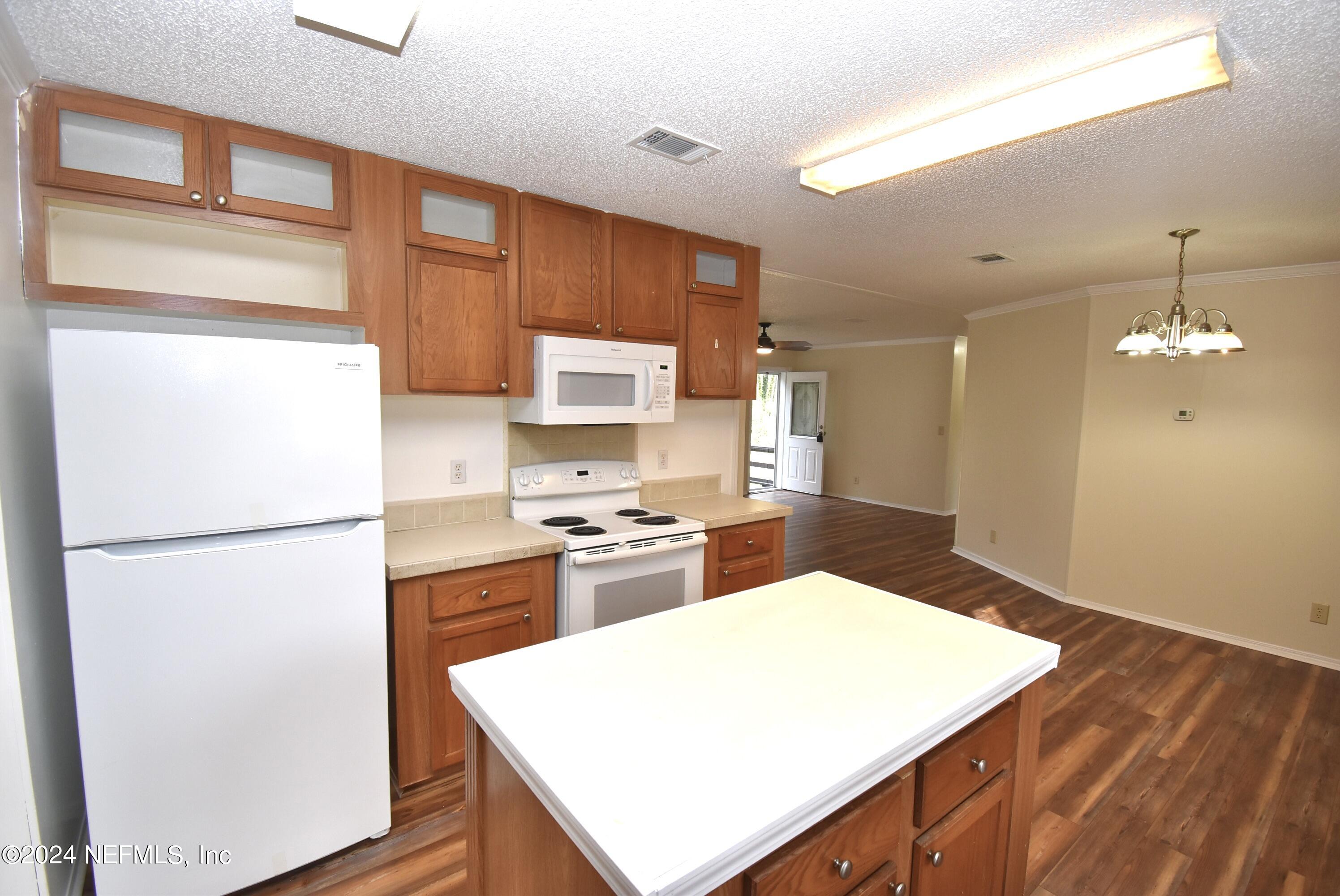 989 Shell Street Welaka, FL 32193 - Photo 11 of 34 a kitchen with a refrigerator a stove top oven a sink and dishwasher