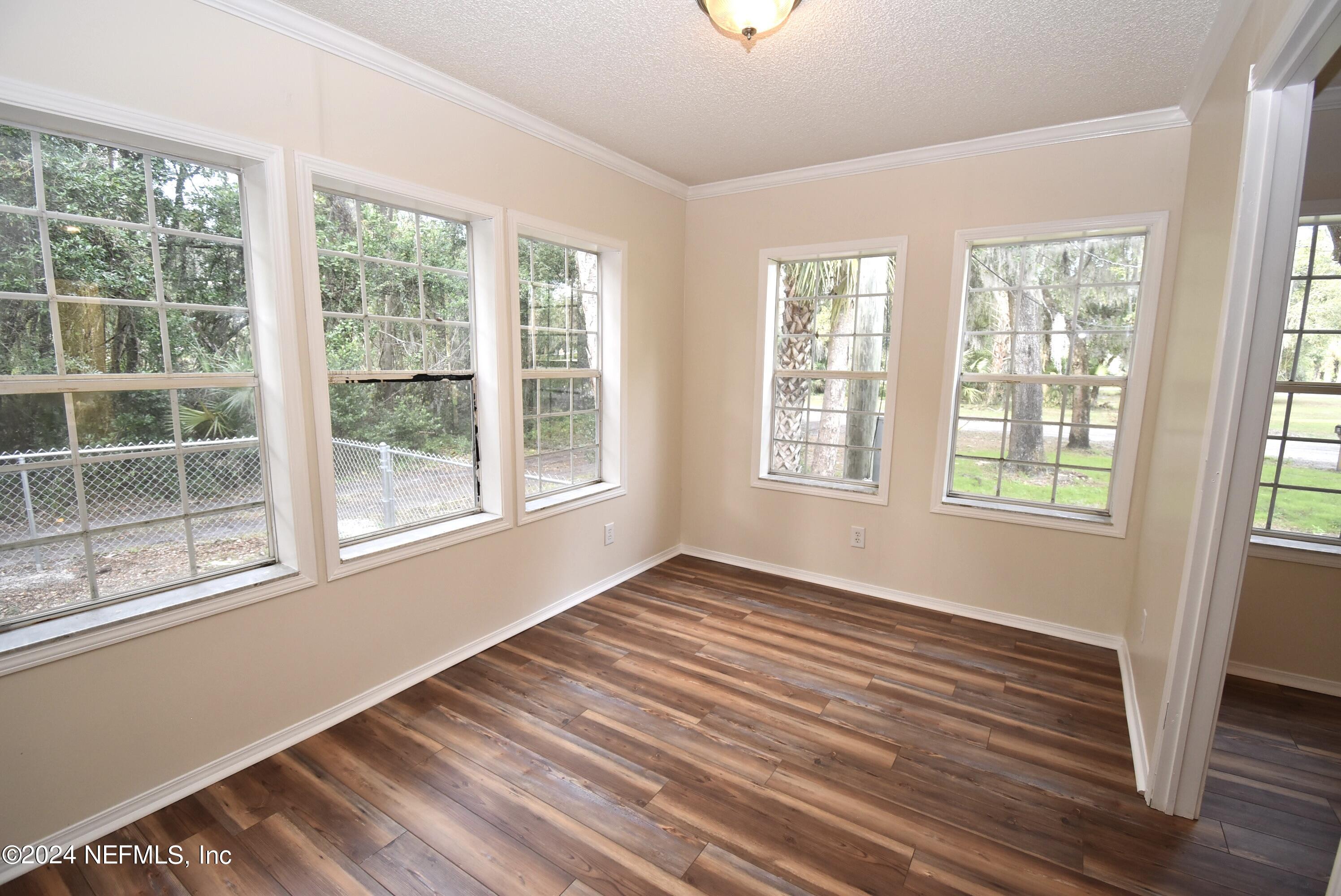989 Shell Street Welaka, FL 32193 - Photo 17 of 34 a view of an empty room with wooden floor and a window