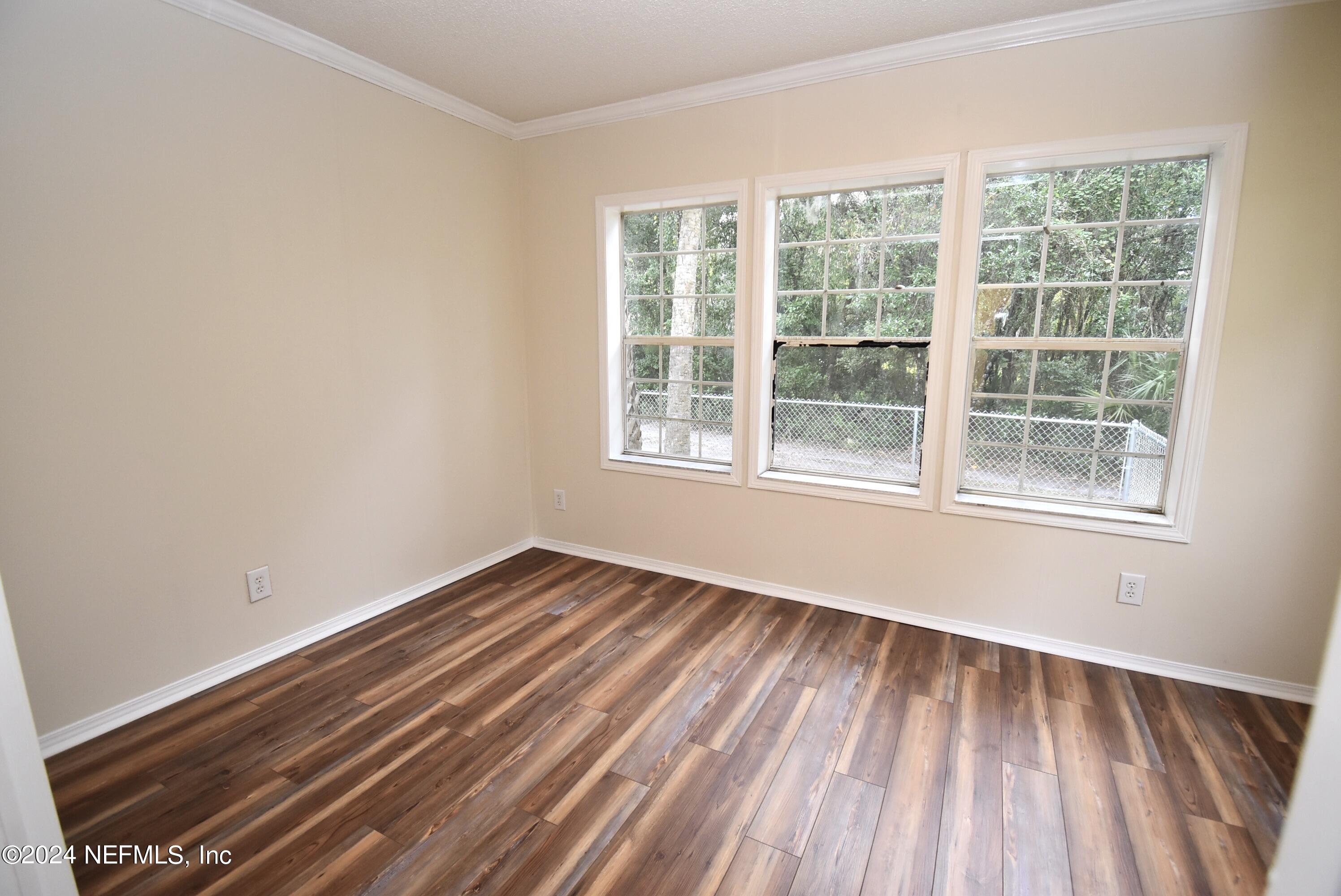 989 Shell Street Welaka, FL 32193 - Photo 18 of 34 a view of an empty room with wooden floor and a window