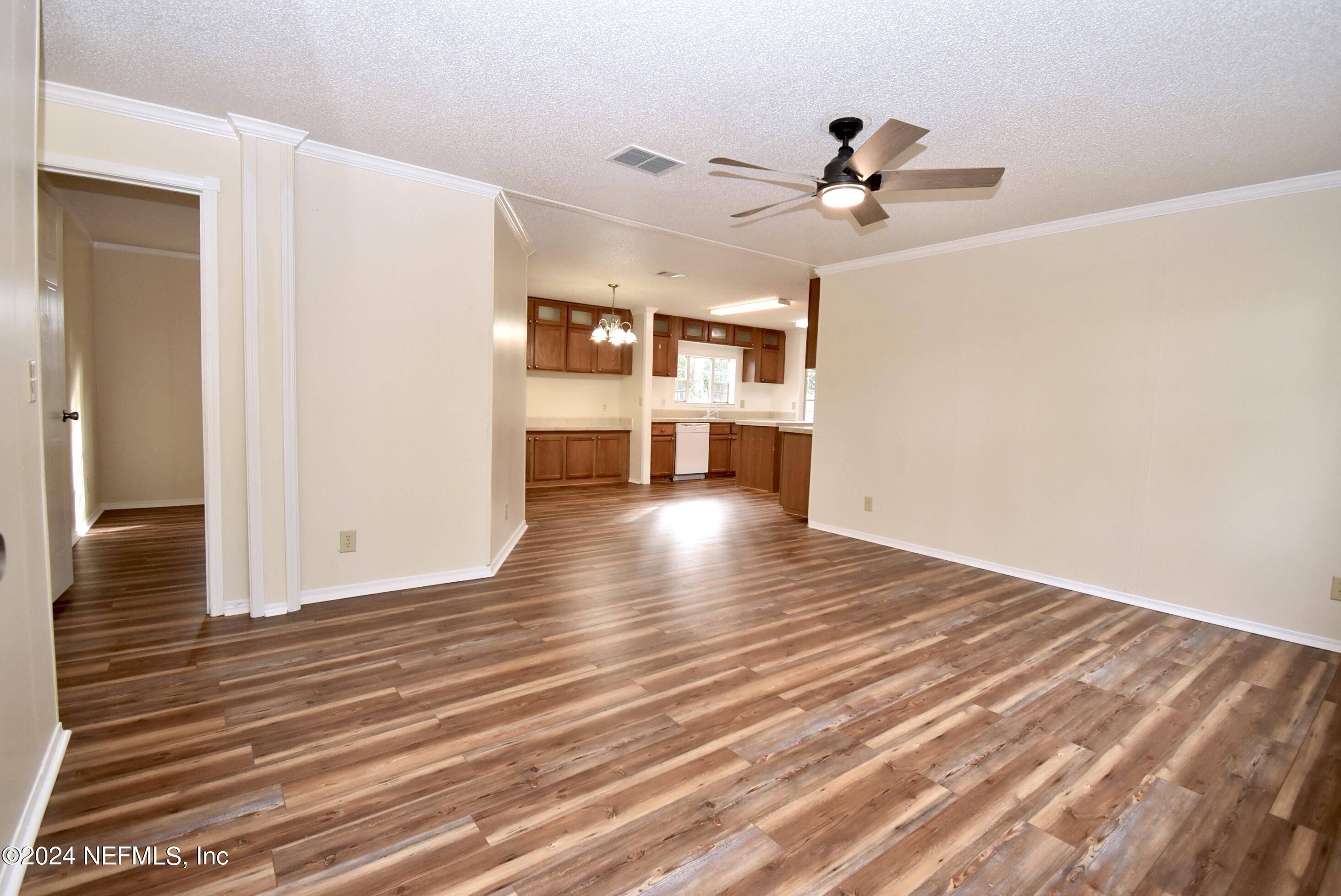 989 Shell Street Welaka, FL 32193 - Photo 25 of 34 a view of a livingroom with wooden floor and a ceiling fan