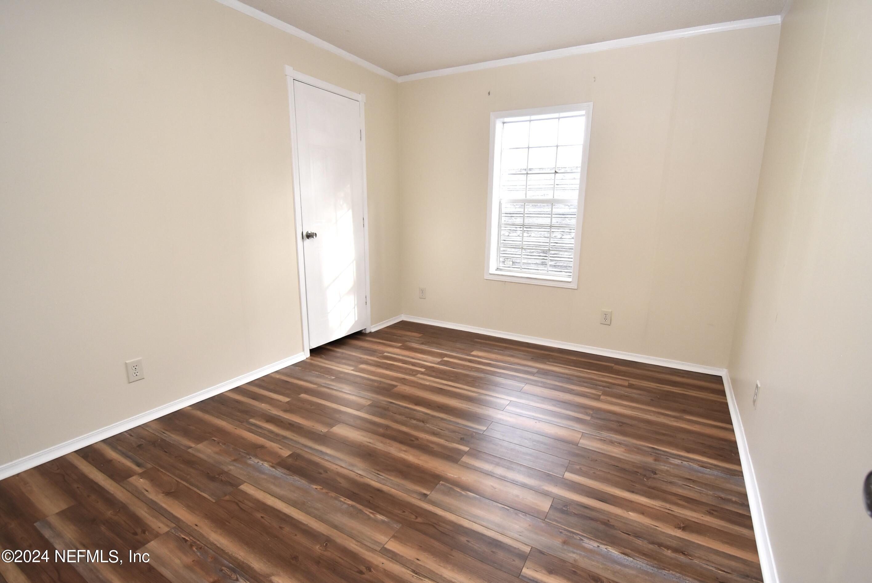 989 Shell Street Welaka, FL 32193 - Photo 29 of 34 an empty room with wooden floor and windows