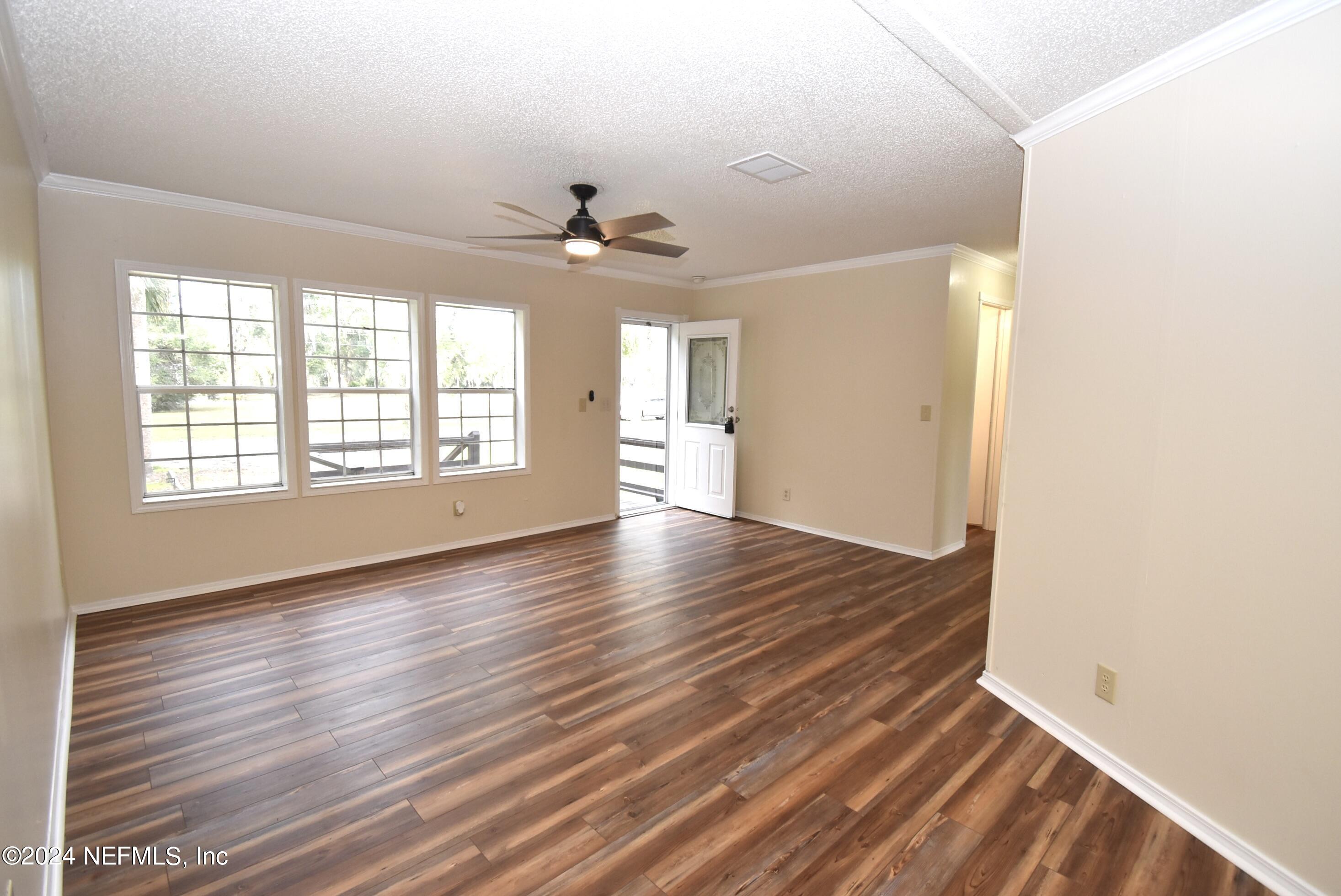 989 Shell Street Welaka, FL 32193 - Photo 7 of 34 wooden floor in an empty room with a window