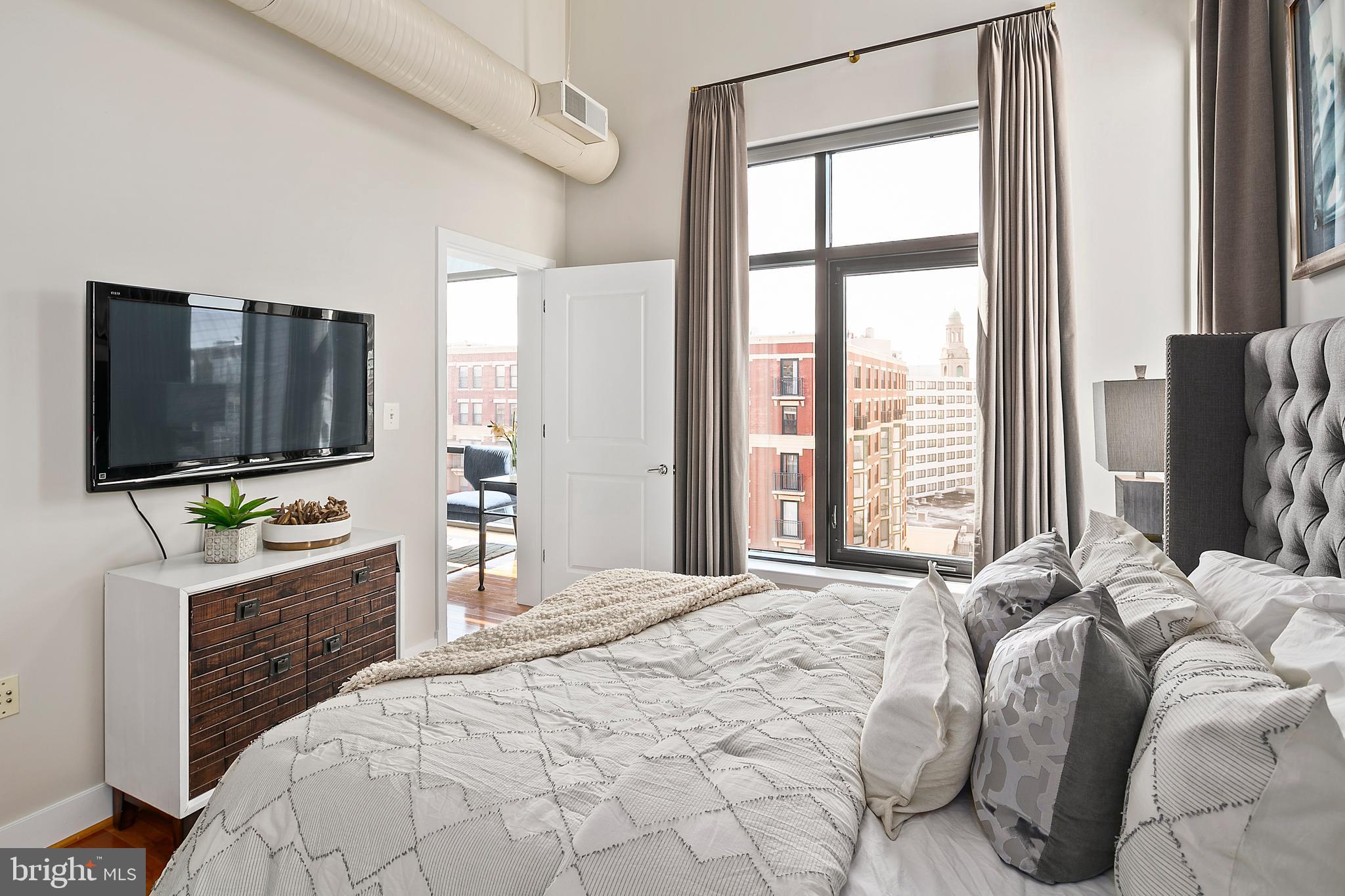 1211 13th Street Northwest, Unit 803 Washington, DC 20005 - Photo 15 of 29 a bedroom with a bed tv and a large window