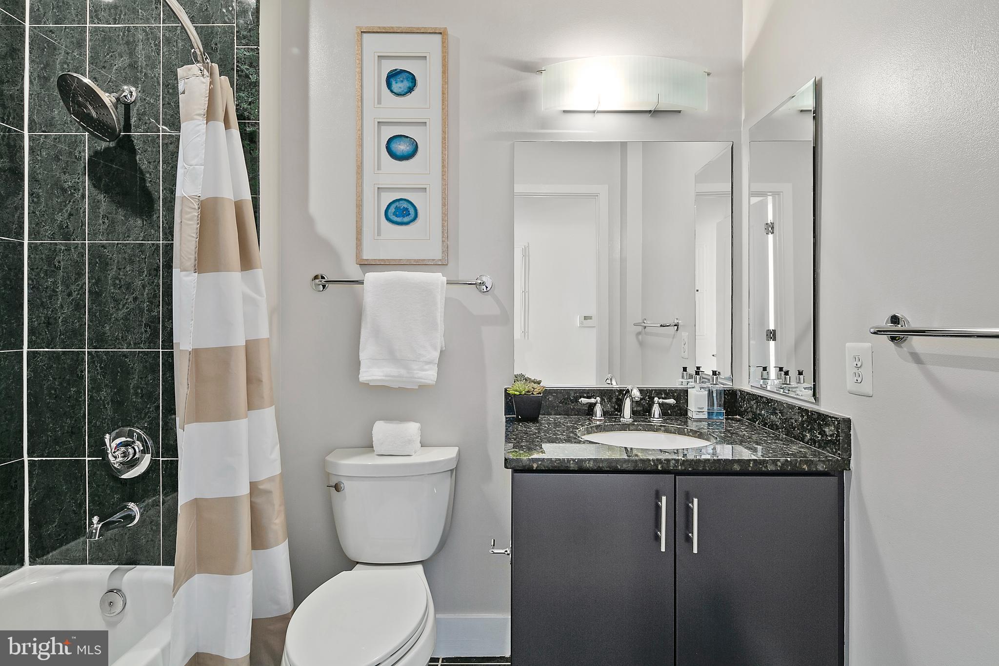 1211 13th Street Northwest, Unit 803 Washington, DC 20005 - Photo 20 of 29 a bathroom with a granite countertop sink toilet and shower