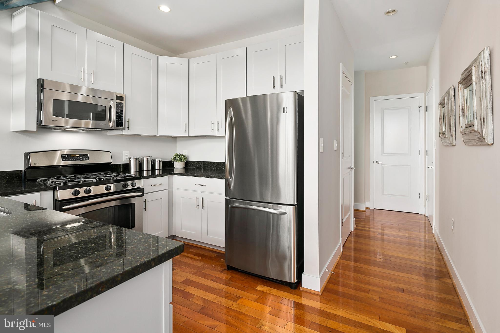 1211 13th Street Northwest, Unit 803 Washington, DC 20005 - Photo 4 of 29 a kitchen with stainless steel appliances granite countertop a refrigerator stove and microwave