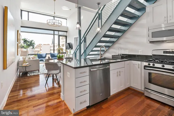 a kitchen with stainless steel appliances granite countertop a stove and cabinets