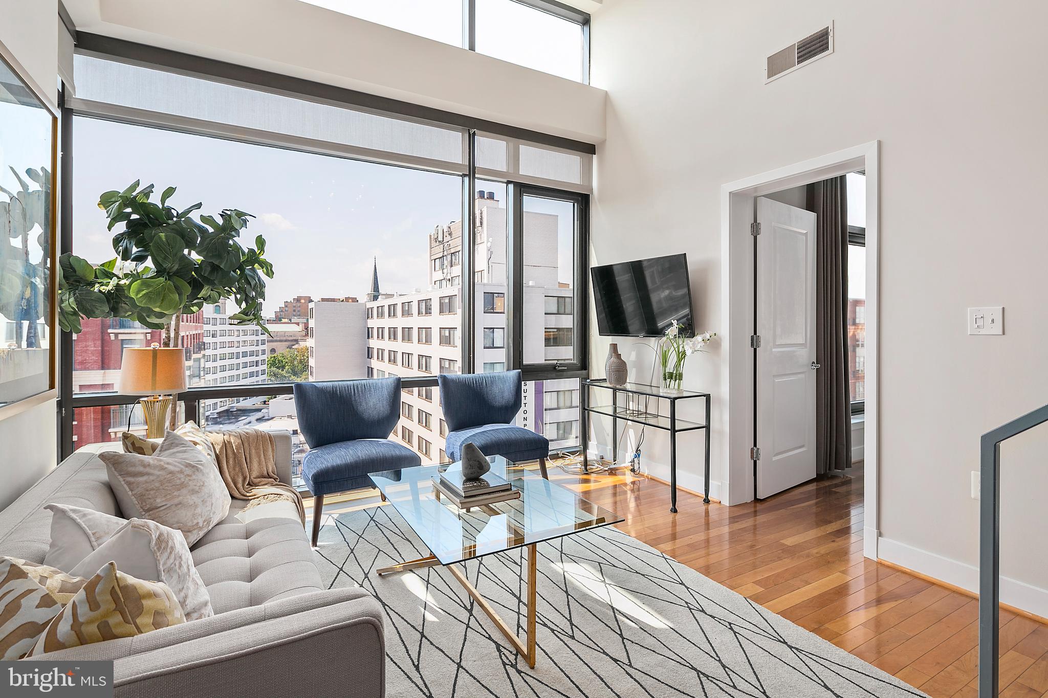 1211 13th Street Northwest, Unit 803 Washington, DC 20005 - Photo 7 of 29 a living room with furniture floor to ceiling window and wooden floor