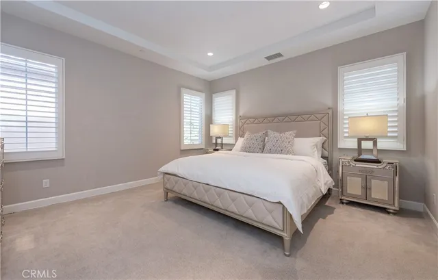 a bedroom with a bed lamp and a large window