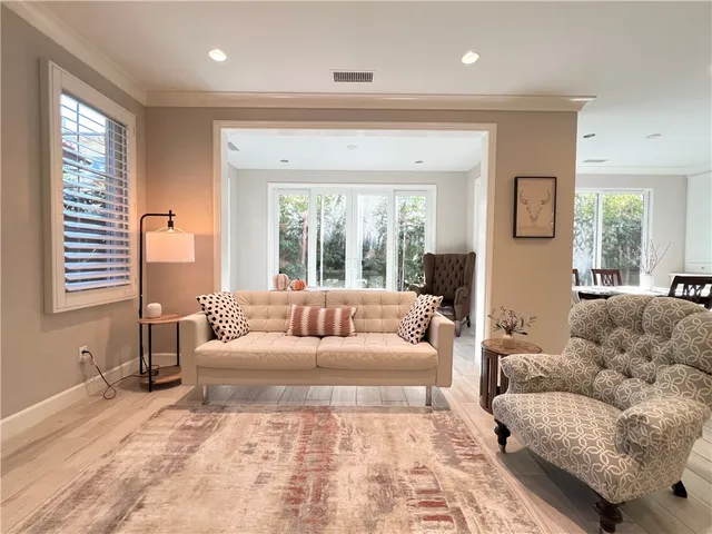 a open kitchen with stainless steel appliances granite countertop a stove a sink a refrigerator with white cabinets and wooden floor