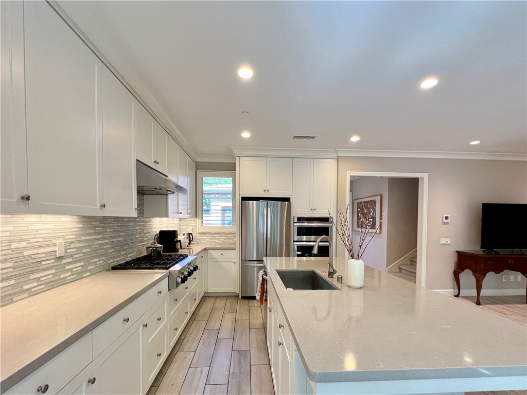 60 Trotter Irvine, CA 92602 - Photo 6 of 24 a kitchen with stainless steel appliances granite countertop a sink dishwasher stove refrigerator and cabinets with wooden floor