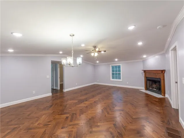 a view of an empty room with a fireplace and a window