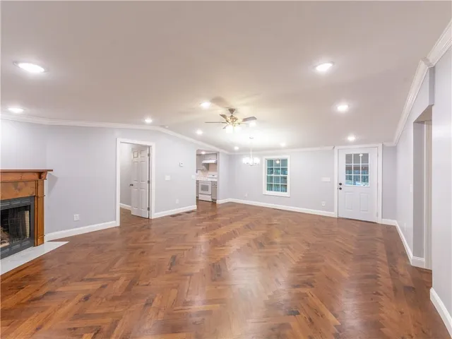 an empty room with large windows and a fireplace