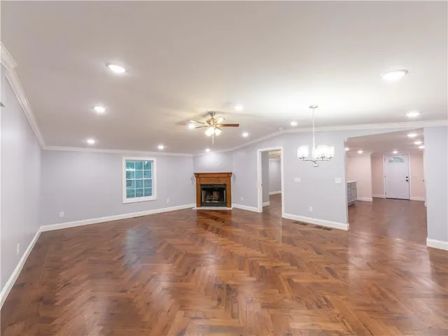 a large kitchen with wooden floors and white cabinets