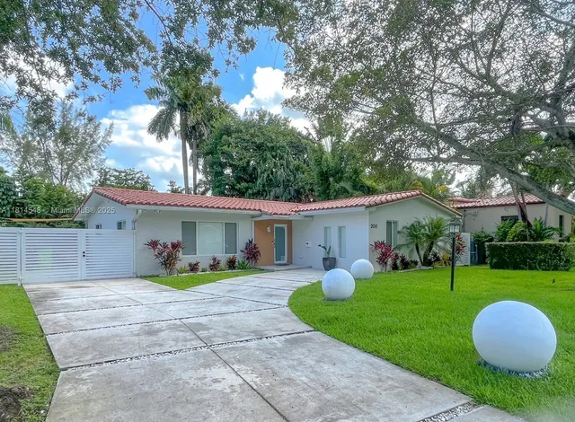 a view of a house with backyard and a tree
