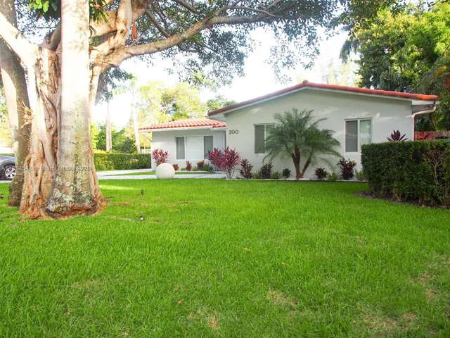 a view of a house with a yard and tree