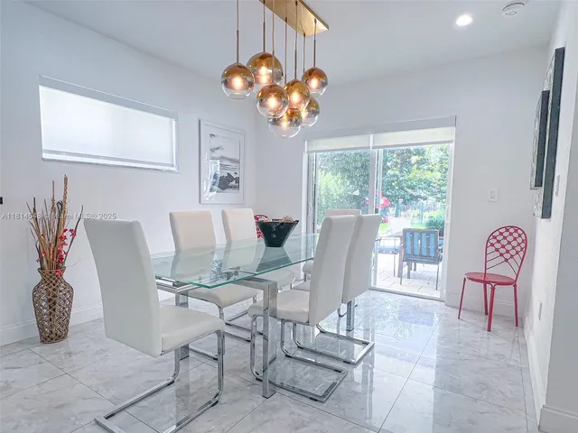 a dining room with furniture a large window and a chandelier