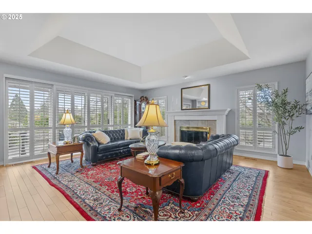 a living room with furniture a rug a fireplace and a large window