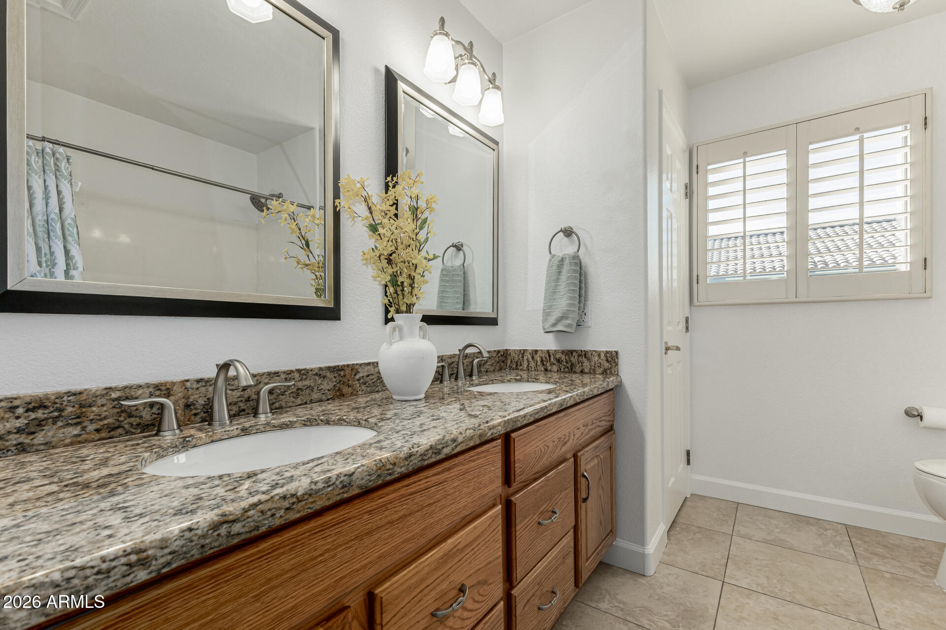 1099 South Justine Court Gilbert, AZ 85296 - Photo 33 of 60 a bathroom with a granite countertop sink and a mirror